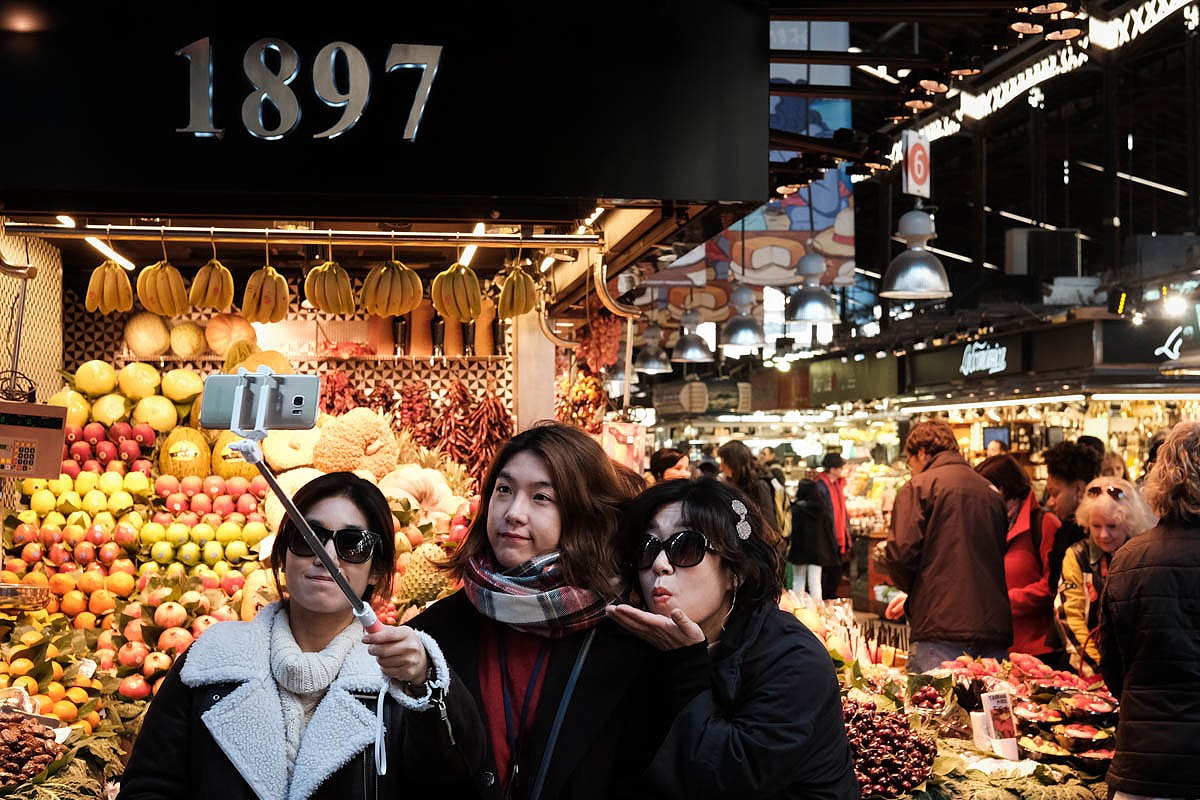 Unes turistes aquest dijous davant d'una parada que ven fruita tallada